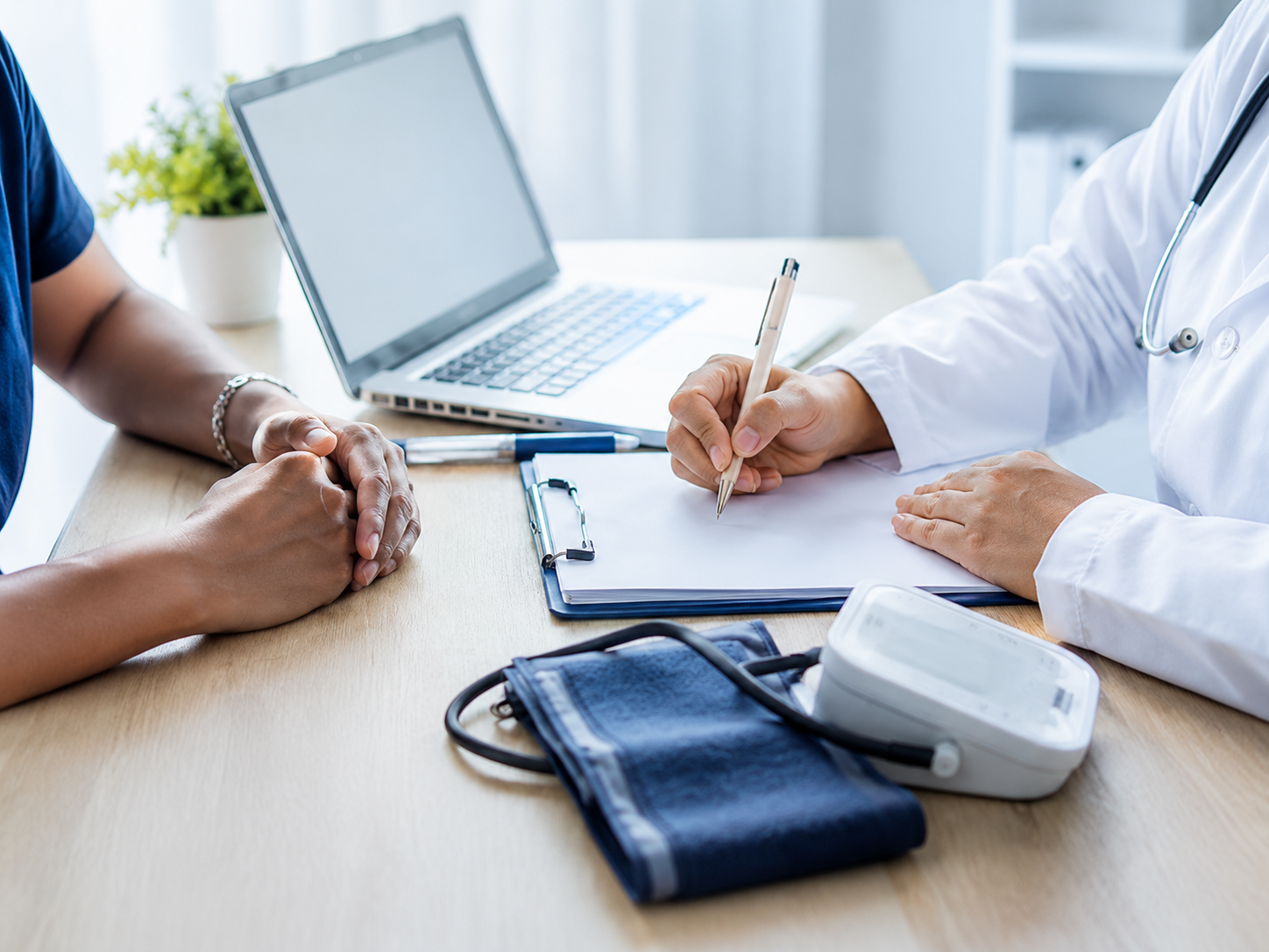 Médico preenchendo o laudo durante uma avaliação clínica